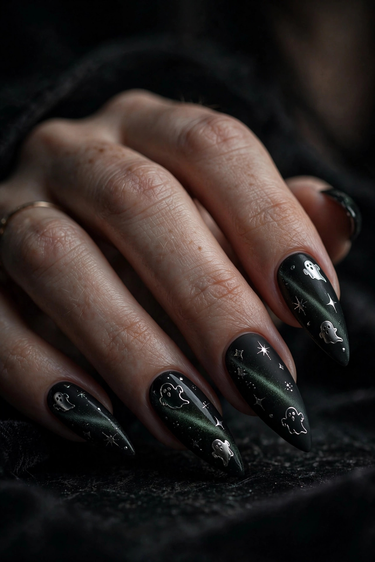 Matte black stiletto nails with magnetic cat-eye shimmer and chrome ghost nail art